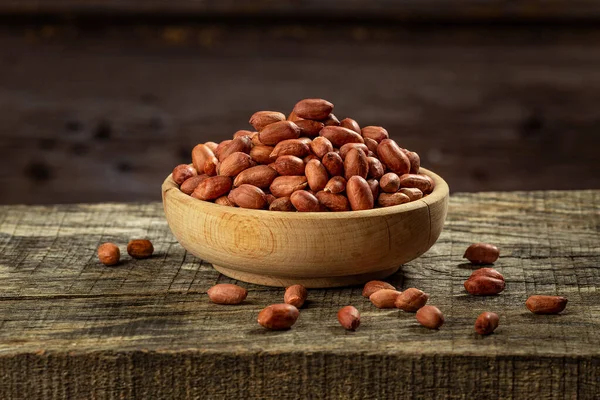 Sušené neoloupané arašídy v dřevěné misce Stock Fotografie