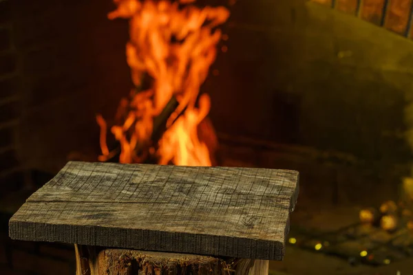 Drewniana deska przed kominkiem z palącym się drewnem. — Zdjęcie stockowe