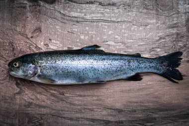 Ahşap masada çiğ taze alabalık.