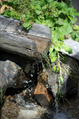 Su için ahşap oluk. Dağ suyu imalathaneye gidiyor. Berrak dağ suyuyla ilkbahar.