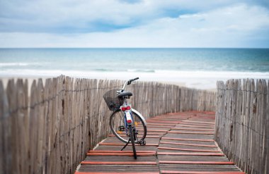 Kumuldan deniz manzarası. Ön planda bir bisiklet..