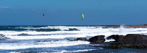Kite surfing on the blue sea against the blue sky in the summer. Kiteboarding. Extreme sport. Entertainment and sports activities. Healthy lifestyle.