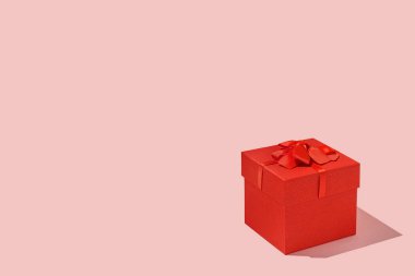 Pembe arka planda kırmızı hediye kutusu