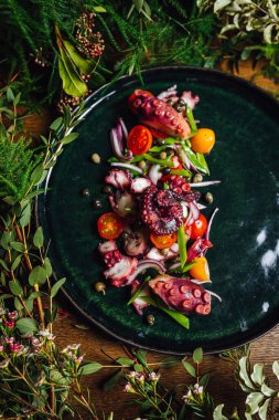 Ahtapot dokunaçlı deniz salatası ve yeşil bitkilerle süslenmiş ahşap masa üzerinde sebzeler, Michelin yıldızı yiyeceği.