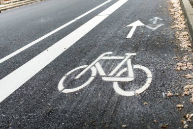 Şehirde yeni inşa edilmiş bisiklet yolu, bisiklet yolu. Kaldırımdaki beyaz boyayı imzala. Yaz. Asfaltta bisiklet trafik tabelası var.
