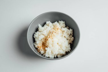 Beyaz pirinç ve parlak arka planda gri kâse.