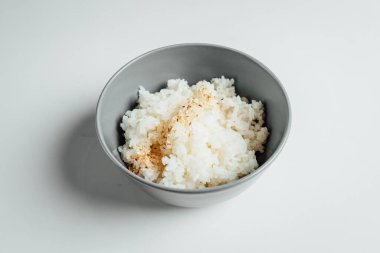 Beyaz pirinç ve parlak arka planda gri kâse.