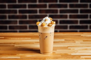 Buzlu paket kahve, sütlü kafe latte ve ahşap masada patlamış mısır, kahve sho