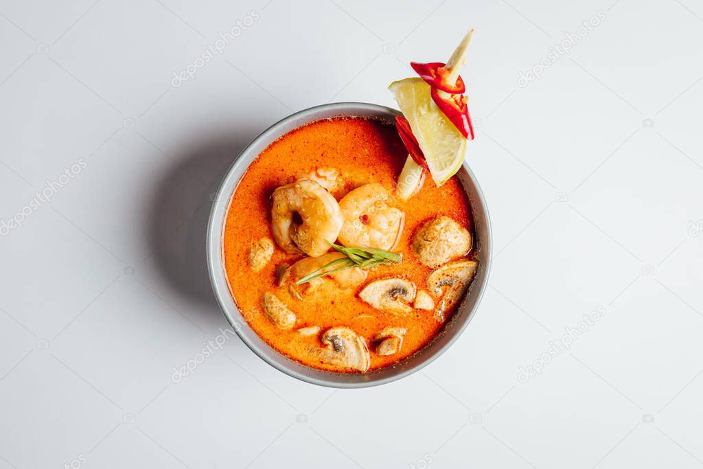 Spicy Tom Yam soup with shrimps and mushrooms on white background