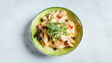 Tabağında peynir ve roka olan taze ve lezzetli bir makarna.