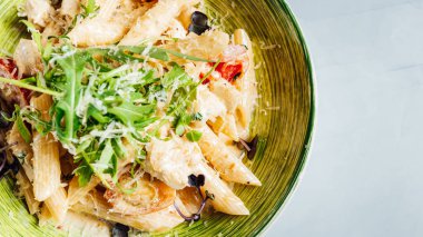 Tabağında peynir ve roka olan taze ve lezzetli bir makarna.