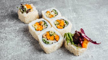 Sebzeli vejetaryen suşi, taş desenli masada. 