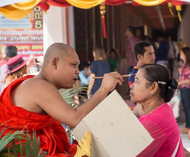 : Suphanburi, Thailand-Şubat 22, 2016: tanımlanamayan keşiş anoints kutsal toz, wat Palaylai,: Suphanburi, Budist alnına Şubat'ta 22,2016