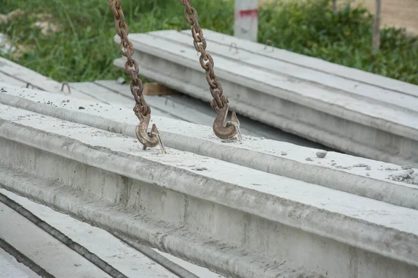 Içando pilhas poste de concreto com guindaste usando fundas de metal — Fotografia de Stock