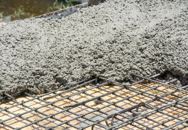 O concreto molhado é derramado no reforço de aço de malha de arame — Fotografia de Stock