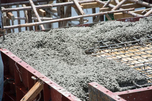 Trabajador vertiendo obras de hormigón en el sitio de construcción — Foto de Stock