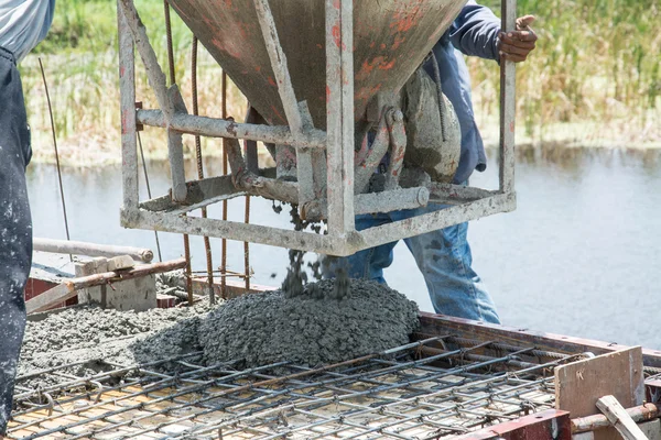 Pekerja menuangkan karya beton di lokasi konstruksi — Stok Foto