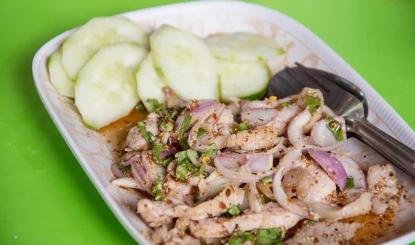 Thajské jídlo kořeněné vepřové salát, Nam Tok Moo, na zeleném pozadí — Stock fotografie