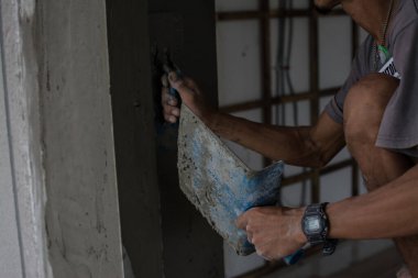 İnşaat duvarında alçı beton işçisi.