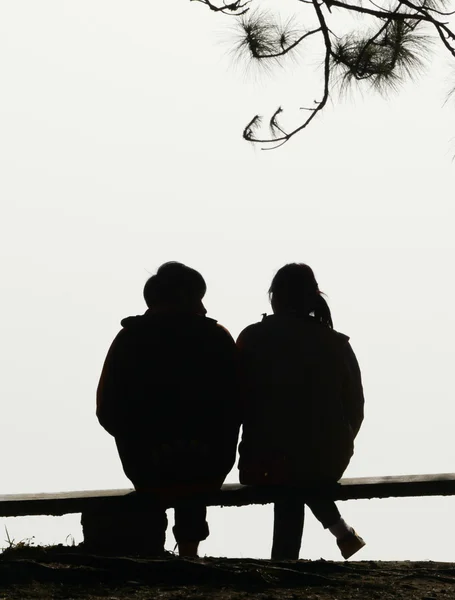 Silhouette couple amour assis sur banc — Photo
