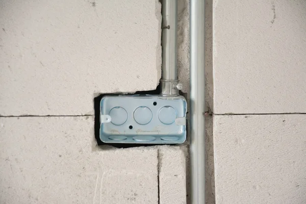 Elsystem på vägg på byggarbetsplats, utlopp med järnrör — Stockfoto