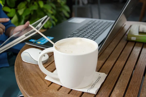 Uomo con una tazza di caffè che lavora sul suo portatile — Foto Stock