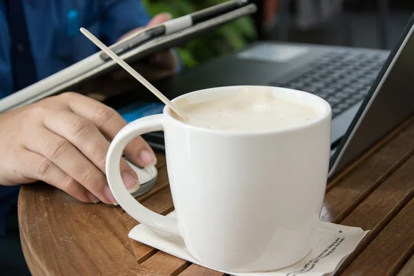 Man with a cup of coffee working on his laptop — Stock Photo, Image