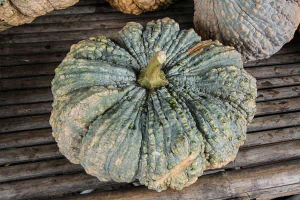 Autumn pumpkins with leaves on wood — Stock Photo, Image