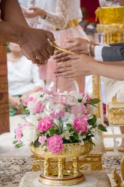 El büyükleri Tay kültürünün düğün töreninde kutsal su aldıktan bir gelin