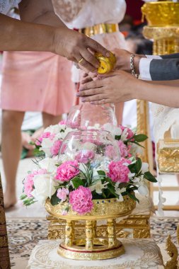 El büyükleri Tay kültürünün düğün töreninde kutsal su aldıktan bir gelin