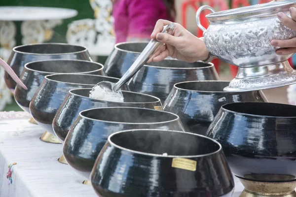 Puts food offerings in a Buddhist monk's alms bowl — Stock Photo, Image