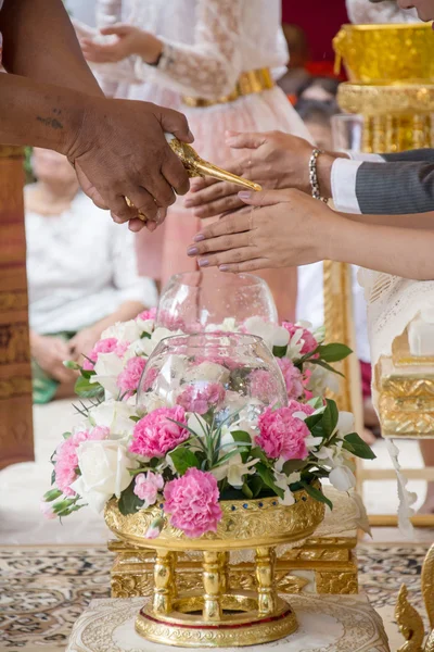 Hand van een bruid wijwater ontvangen oudsten in de ceremonie van het huwelijk van de Thaise cultuur — Stockfoto