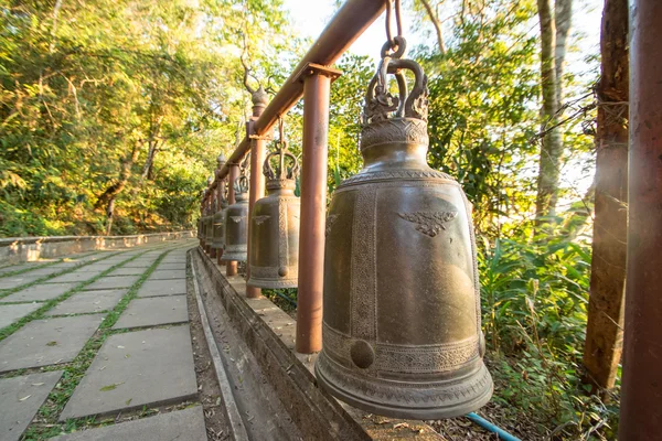 Brass bells hang in row in buddhist temple, Thailand — Stock Photo, Image