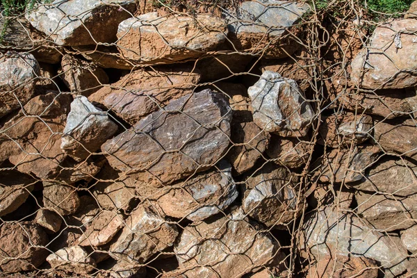 Piedra en red metálica —  Fotos de Stock