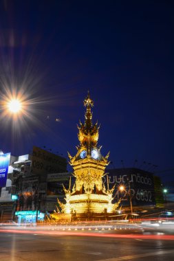Chiang Rai-Aralık 17: sokakta gece üzerinde 17 Aralık 2014 yılında Chiang Rai, Tayland Tayland görsel sanatçı yazar Kositpipatat, 2008 yılında kurulan altın saat kulesi çevresinde ışık rotaları.