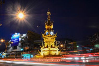 Chiang Rai-Aralık 17: sokakta gece üzerinde 17 Aralık 2014 yılında Chiang Rai, Tayland Tayland görsel sanatçı yazar Kositpipatat, 2008 yılında kurulan altın saat kulesi çevresinde ışık rotaları.