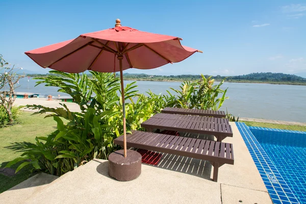 Piscine avec transat et parasol rouge à Chiangrai, Thaïlande — Photo