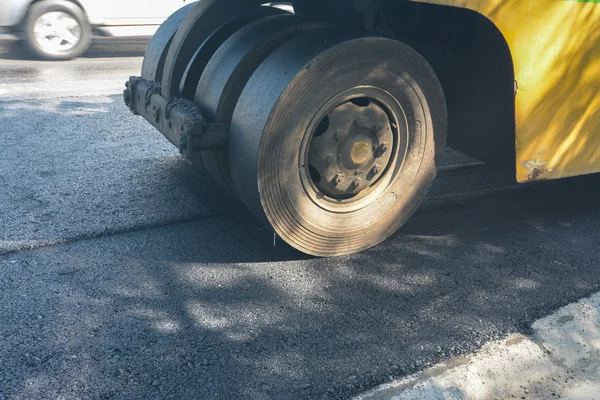 Asfalt roller werkt op de straat die werd onlangs hersteld. De snelweg die is hersteld heeft onlangs asfalt. Een enorme zware apparatuur compactor of roller de asfaltweg comprimeren. — Stockfoto