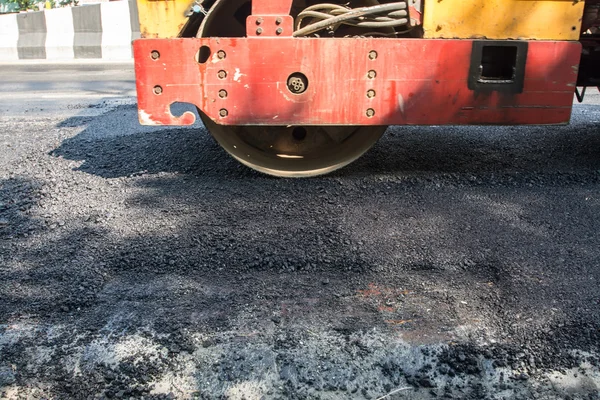 Asfalt roller werkt op de straat die werd onlangs hersteld. De snelweg die is hersteld heeft onlangs asfalt. Een enorme zware apparatuur compactor of roller de asfaltweg comprimeren. — Stockfoto