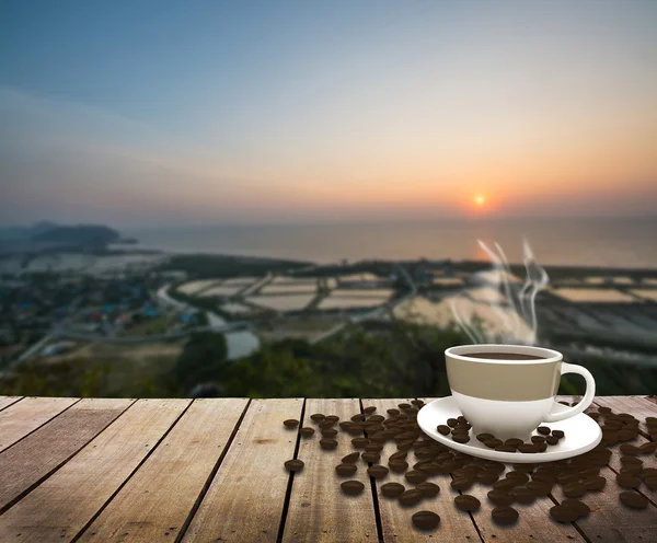 Csésze kávé asztal tengerre napkeltekor — Stock Fotó