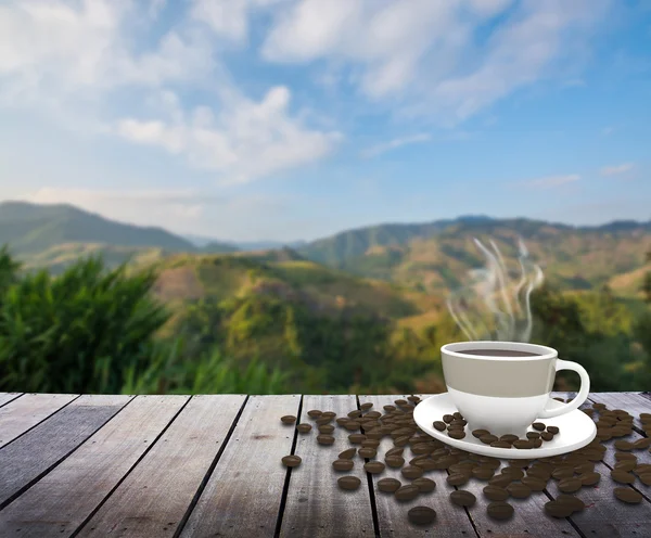 Cup with coffee on table over mountains landscape