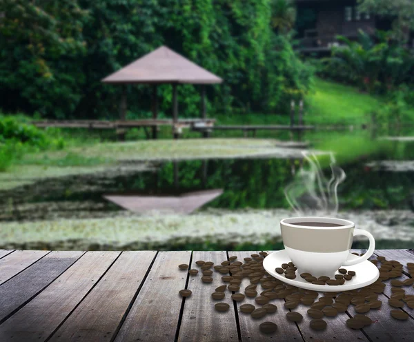 Чашка кофе на столе над озером — стоковое фото