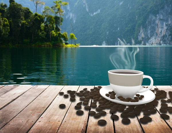 Copo com café na mesa sobre o lago — Fotografia de Stock