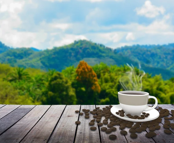 Copo com café na mesa sobre montanhas paisagem — Fotografia de Stock