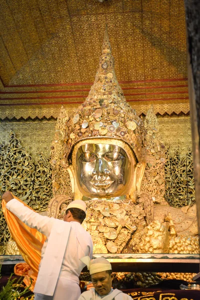 MANDALAY - AUGUST 01 : Unidentified Burmese monk is cleaning Buddha statue with the golden paper at Mahamuni Buddha temple, August 01, 2015 in Mandalay, Myanmar. — Stock Photo, Image