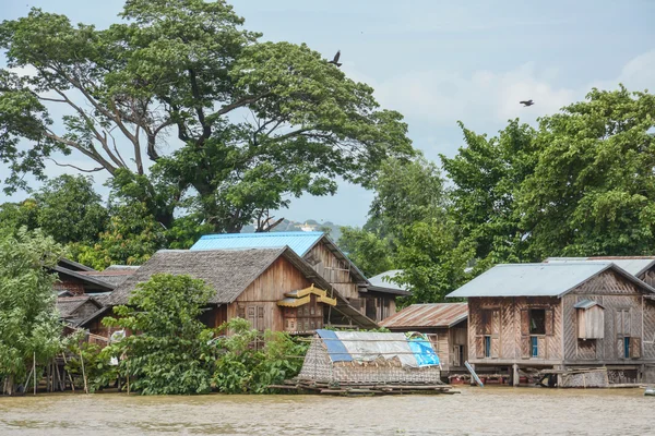 Traditional stilts wooden and bamboo houses and long boats on Ayewadee river in Mandalay, Myanmar (Burma) — Stock Photo, Image