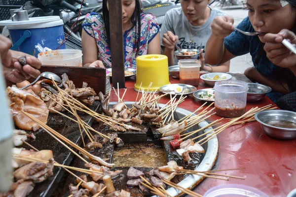 MANDALAY, MYANMAR - AUGUST 01 : People eating pig tail- Myanmar street food on August 01, 2015 in Mandalay, Myanmar — Stock Photo, Image