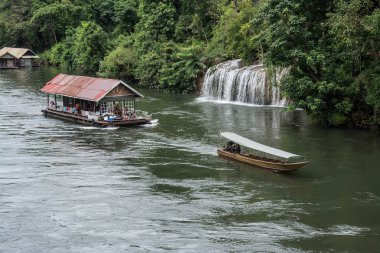 Kwai Nehri 'nde yüzen evi olan uzun kuyruklu bir tekne. Sai Yok Yai şelalesinde çekilmiş. Tayland 'dan Kanchanaburi.