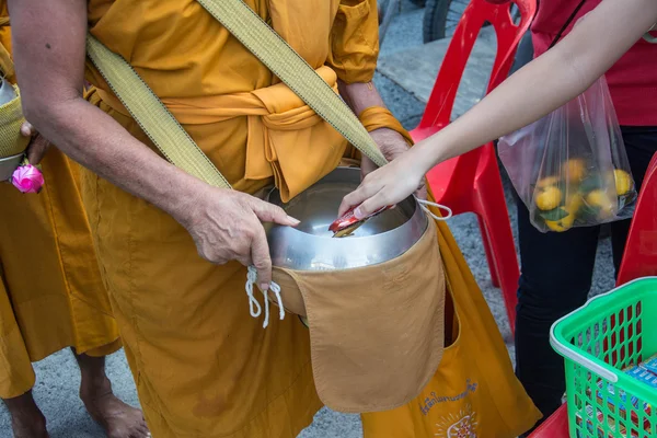 พระภิกษุสงฆ์จะได้รับอาหารจากผู้คนสําหรับวันสิ้นสุดของพระพุทธศาสนา — ภาพถ่ายสต็อก