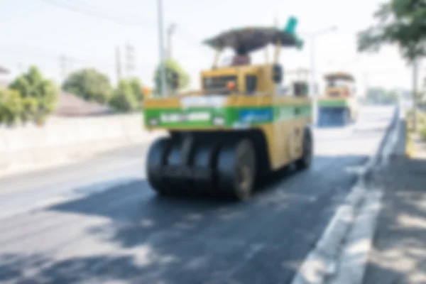 Foto borrosa de rodillo de asfalto trabajando en la calle —  Fotos de Stock